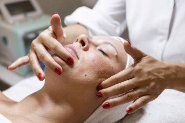Kozmetoloji prosedürü, güzellik stüdyosunda yüz masajı. Ellerinizi ve yüzünüzü kapatın. Doğal sorunlu cilt. Klinik ya da güzellik salonu