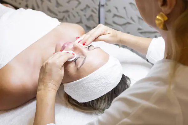 Güzellik atölyesinde kozmetoloji, yüz masajı ve maske. Ellerinizi ve yüzünüzü kapatın. Doğal sorunlu cilt. Klinik ya da güzellik salonu