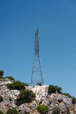 Yüksek voltaj iletim hattı, pilon ve kule bir dağ bölgesi, alan. Yazın mavi gökyüzü