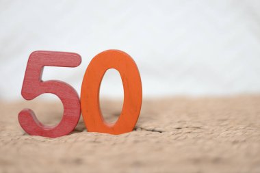 Beyaz bulanık arkaplanda 50 numaralı ahşap ve turuncu figür, tatil tarihi, yıldönümü, metin için fotokopi alanı olan yıldönümü kartı.