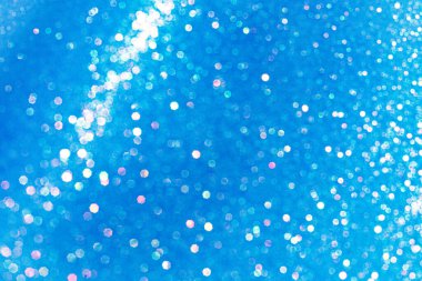 Soyut parıltılı ışıklar mavi ve beyaz arkaplanlı, odaklanmamış, bokeh. Noel ya da Yeni Yıl Festivali ışıl ışıl arka plan, kış tatili kartı kavramı