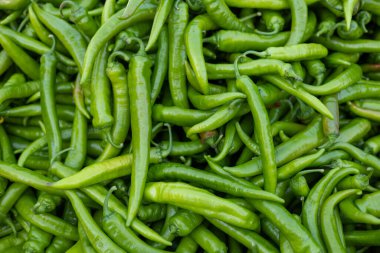 Pazarda ya da pazar tezgahında bir sürü yeşil ve kırmızı kırmızı kırmızı biber mevsimlik sağlıklı sebzeler, üst görünüm arka plan