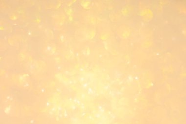 Soyut ışıltılı ışıklar altın ve beyaz arkaplanlı, odaklanmamış, bokeh. Noel ya da Yeni Yıl Festivali ışıl ışıl arka plan, kış tatili kartı kavramı