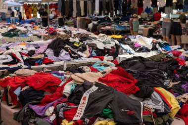 03.08.2024 Antalya, Türkiye - Pazar. Türkçe tezgahında çeşitli sahte tasarımcı kıyafetleri var. Giysiler üst üste yatar. Ucuz fiyatlar ve moda markalarına alternatifler. Eski satışlar