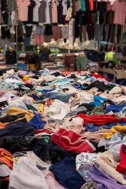 Antalya, Türkiye - 3 Ağustos 2024 - Pazar. Türkçe tezgahında çeşitli sahte tasarımcı kıyafetleri var. Giysiler üst üste yatar. Ucuz fiyatlar ve moda markalarına alternatifler. Eski satışlar