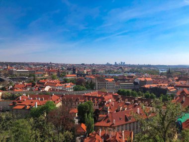 Prag 'ın kırmızı ve turuncu çatıları ve Prag' ın tarihi kentinin düzinelerce kulesi. Prag 'ın şehir manzarası güneşli bir günde mavi gökyüzü, Çek.