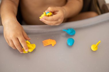Bebek el oyunları masasında renkli mavi ve sarı plastikler ve hayvanlar, çocuklarda iyi motor becerilerin ve hayal gücünün gelişimi, yürümeye başlayan oyunlar ve boş zamanlarında