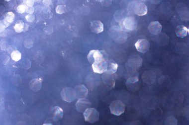 Soyut parıltılı ışıklar mavi ve beyaz arkaplanlı, odaklanmamış, bokeh. Noel ya da Yeni Yıl Festivali ışıl ışıl arka plan, kış tatili kartı kavramı