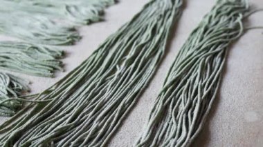Makarna yapmak için hamur kurusıkı. Masada ıspanak hamuru var, doğranmış ve sıralanmış, un serpiştirilmiş. Makarna, vermicelli, spagetti. Aile işi ve mini fabrika.