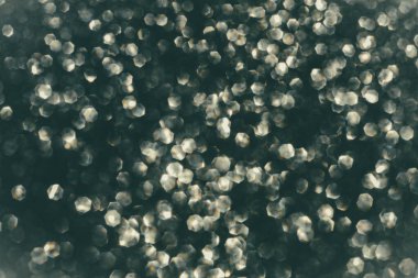 Soyut parıltılı ışıklar koyu gümüş, gri ve beyaz renkli arka plan, odaklanmamış, bokeh. Noel ya da Yeni Yıl Festivali ışıl ışıl arka plan, kış tatili kartı kavramı