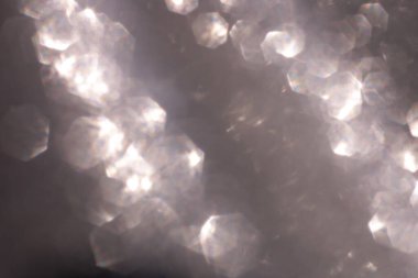 Soyut parıltılı ışıklar koyu gümüş, gri ve beyaz renkli arka plan, odaklanmamış, bokeh. Noel ya da Yeni Yıl Festivali ışıl ışıl arka plan, kış tatili kartı kavramı