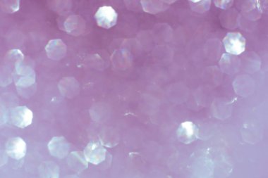 Soyut ışıltılı ışıklar desenli menekşe ya da mor ve beyaz arka plan, odaklanmamış, bokeh. Noel ya da Yeni Yıl Festivali ışıl ışıl arka plan, kış tatili kartı kavramı