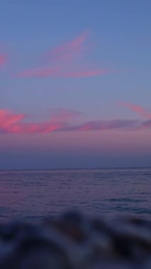 Ufuk boyunca pembe renkler saçan çarpıcı bir günbatımına tanık olun. Yumuşak dalgalar kıyıya doğru süzülürken barışçıl bir atmosfer yaratıyor. Alacakaranlıkta güzelliği tecrübe etmek. Kısmen bulanık arkaplan