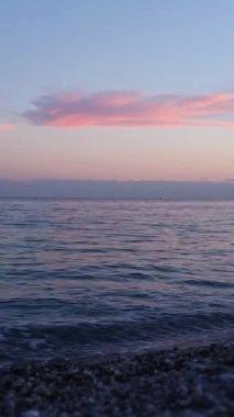 Ufuk boyunca pembe renkler saçan çarpıcı bir günbatımına tanık olun. Yumuşak dalgalar kıyıya doğru süzülürken barışçıl bir atmosfer yaratıyor. Alacakaranlıkta güzelliği tecrübe etmek. Kısmen bulanık arkaplan