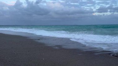 Akşamları kumlu bir plajda dalgalar kıyıya vurur, gökyüzünde bulutlar yükselir. Sakin atmosfer, gün batımına dönerken dinlenmeyi ve düşünmeyi davet eder. Türkiye 'de kış