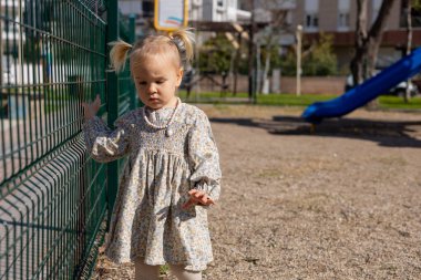 Üzgün kız çocuğu sorunlu çocuk oyun parkında tek başına yürüyor zorbalık, depresyon, çocuk koruması ya da yalnızlık, terk edilmiş çocuk oyunu konsepti