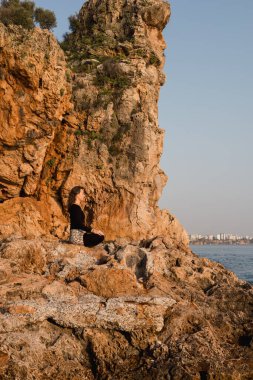 Dişi yogi, gün batımında okyanus ya da deniz kenarında yoga yapıyor. Genç kıvırcık kadının lotus yogası pozunda meditasyon yapması. Milenyum kızı kayalık sahilde yoga ve meditasyon yapıyor.