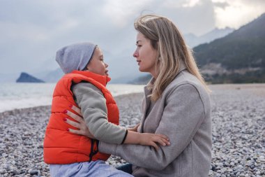 Kış günü, bir anne ve oğlu çakıl taşı plajında yürek ısıtan bir anın tadını çıkarırlar. Burunlarından öpmek ve dokunmak. Sakin deniz ve uzak dağlar sevgileri için sakin bir zemin oluşturur..