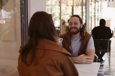 Sıcak bir kafede masada oturan iki kişi arasında romantik ya da dostça bir ilişki başlar. Geniş pencerelerden içeri akan doğal ışık, rahat atmosferi arttırır..
