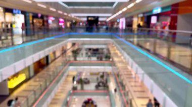 Bulanık renkli alışveriş merkezi bölgesi, alışveriş merkezinde yürüyen kalabalıktan arındırılmış insanlar, kapalı kapılar ardında bulanık mağazalar, alışveriş merkezindeki odaksız etkinlikler.. 
