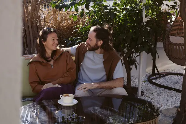 Kadınlar ve erkekler rahat bir kafede küçük bir masada yan yana otururlar. Düşünceli ifadelerle derin bir sohbete dalmışlar. Sıradan spor kıyafetleri, yaşam tarzı anları ve duygular.