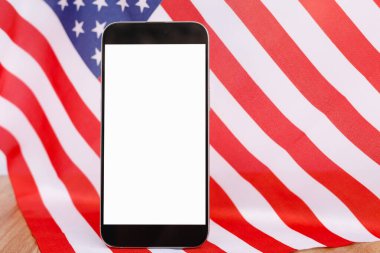 Model tasarım metni veya ABD ulusal bayrağının arkaplanındaki ürün için modern akıllı telefon üzerindeki boş beyaz ekran