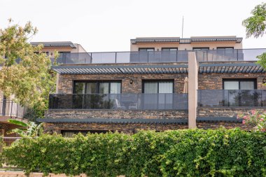 Bodrum, Türkiye 'de balkonları olan modern taş binalar. Yeşillik, doğa ve çağdaş mimarinin bir karışımını sergileyerek, yapıları sarar..