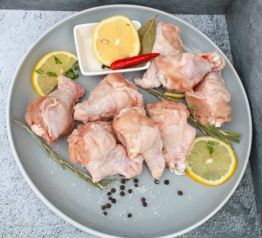 Tabağında baharat olan çiğ tavuk kanatları.