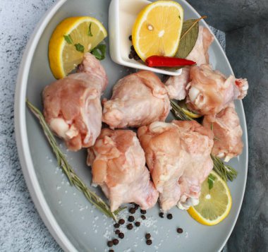 Tabağında baharat olan çiğ tavuk kanatları.