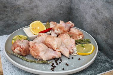 Tabağında baharat olan çiğ tavuk kanatları.
