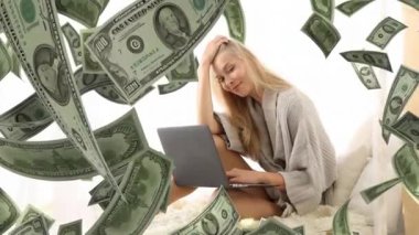 Yatakta para ve dizüstü bilgisayar kullanan güzel bir genç kadın.