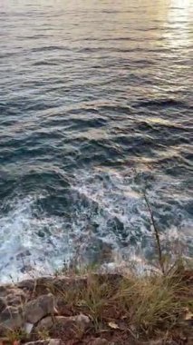 Sveti Stefan adasının kayalıklarında büyüleyici bir günbatımı. Yüksek kalite 4k görüntü