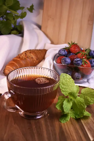 Great country breakfast or dinner. Tea in a glass cup, homemade cakes, fresh aromatic berries, mint.