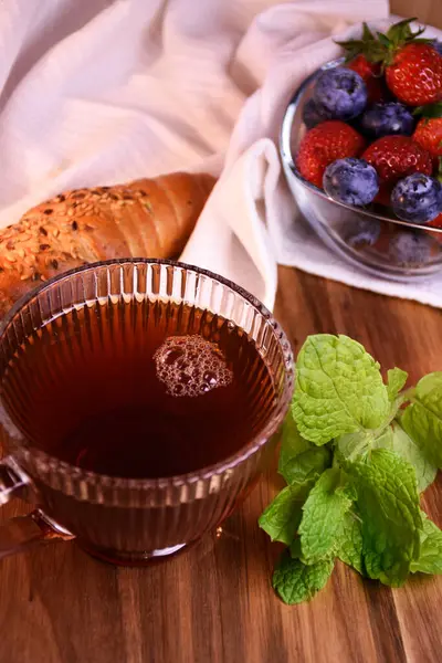 Great country breakfast or dinner. Tea in a glass cup, homemade cakes, fresh aromatic berries, mint.
