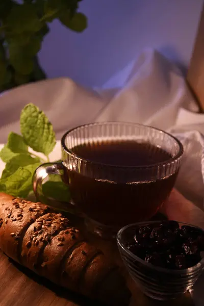 Harika bir köy kahvaltısı ya da akşam yemeği. Bardakta çay, ev yapımı kekler, kurutulmuş böğürtlen, nane.