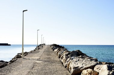 Önde deniz olan bir yolun dikey görüntüsü.