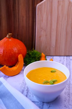 Kremalı ve fıstıklı balkabağı kremalı çorba ve taze ekmek.