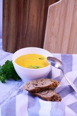 Kremalı ve fıstıklı balkabağı kremalı çorba ve taze ekmek.