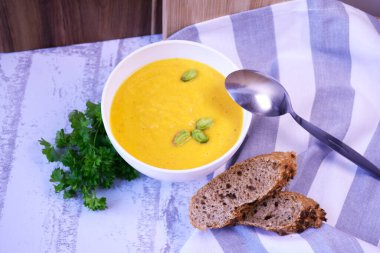 Kremalı ve fıstıklı balkabağı kremalı çorba ve taze ekmek.