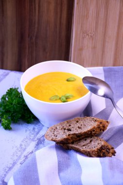 Kremalı ve fıstıklı balkabağı kremalı çorba ve taze ekmek.