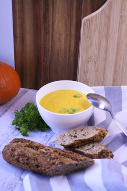 Kremalı ve fıstıklı balkabağı kremalı çorba ve taze ekmek.