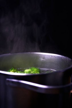 Broccoli in boiling water in a saucepan clipart