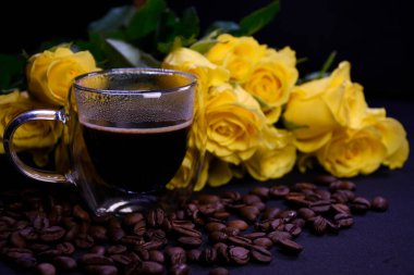 Kahve çekirdeklerinin üzerinde koyu kahve ve sarı güller.