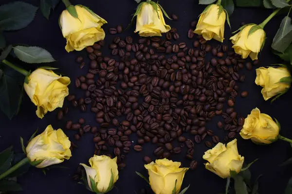 Kahve çekirdeğinin etrafına dizilmiş sarı güller.