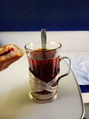 Cam bardakta çay, sahte bir kol ve tren kompartımanında kaşık.