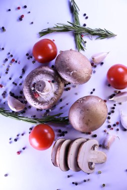 Biber ve domatesli gri arka planda şampiyon mantarları. Vejetaryen yemeği için malzemeler.