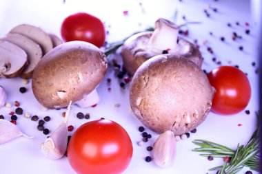 Biber ve domatesli gri arka planda şampiyon mantarları. Vejetaryen yemeği için malzemeler.