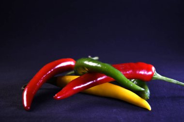 Siyah arka planda çok renkli taze biber.