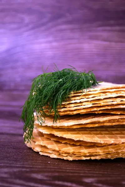 Silja ile tuzlanmış waffle ve ahşap bir masada dereotu.