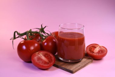 Pembe arka planda taze domates suyu